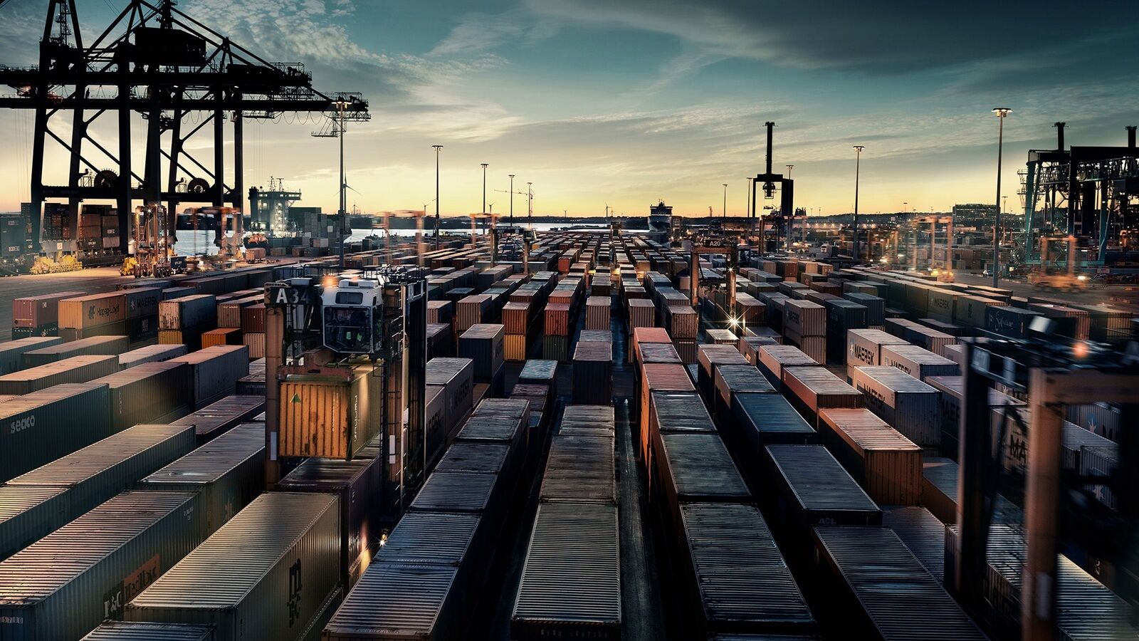 Line-up of containers in a harbour, photographed in sunset